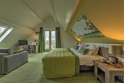 a bedroom with a bed and a couch and a table at De Willigen Logies in Vreeland