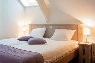 a bedroom with a bed with two pillows and a window at De Willigen Logies in Vreeland