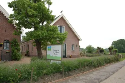 a house with a sign in front of it at De Willigen Logies in Vreeland