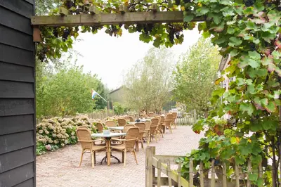 a row of tables and chairs in a garden at De Willigen Logies in Vreeland