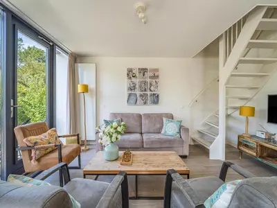 a living room with a couch and a table at Holiday home with sauna in Egmond aan den Hoef