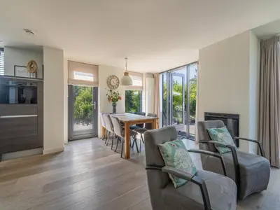 a living room with a dining room table and chairs at Holiday home with sauna in Egmond aan den Hoef