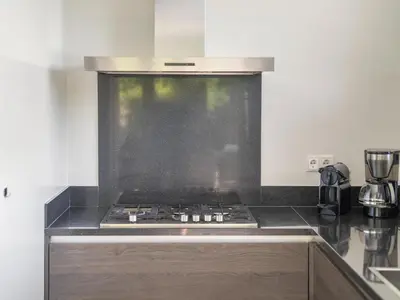 a kitchen with a stove top oven in a kitchen at Holiday home with sauna in Egmond aan den Hoef