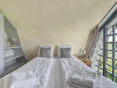 a bedroom with a bed with two pillows at Holiday home with sauna in Egmond aan den Hoef