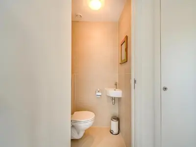 a bathroom with a toilet and a sink at Holiday home with sauna in Egmond aan den Hoef