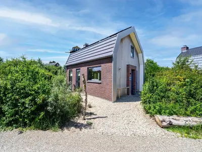 a small brick building with a window at Holiday home with sauna in Egmond aan den Hoef