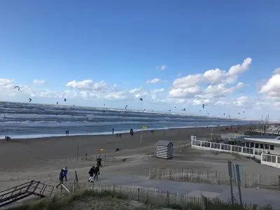 a group of people on a beach flying kites at Evy's place in Zandvoort