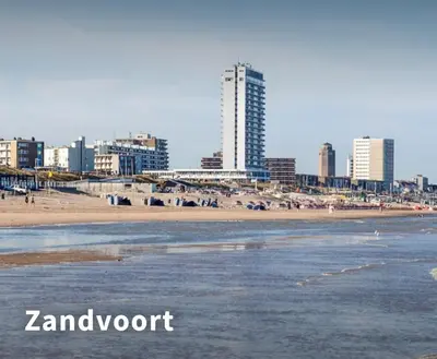a beach in front of a city with tall buildings at Evy's place in Zandvoort