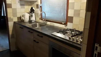 a kitchen with a sink and a stove at Vrijstaande blokhut in Egmond-Binnen