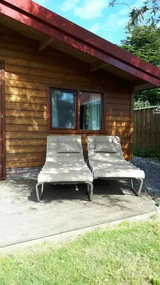 three beds sitting on a porch of a house at Vrijstaande blokhut in Egmond-Binnen