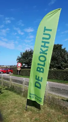 a green sign on the side of a road at Vrijstaande blokhut in Egmond-Binnen