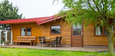 a small wooden cabin with a table and chairs at Vrijstaande blokhut in Egmond-Binnen