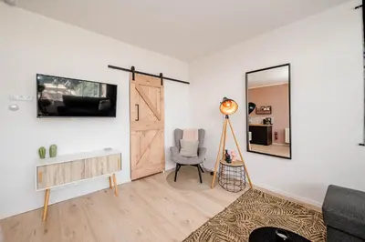 a living room with a chair and a mirror at Amsterdam Beach Apartment 9, Private Garden in Zandvoort