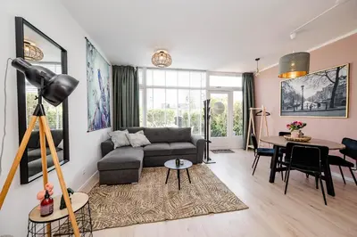 a living room with a couch and a table at Amsterdam Beach Apartment 9, Private Garden in Zandvoort