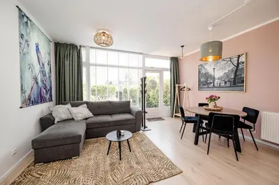 a living room with a couch and a table at Amsterdam Beach Apartment 9, Private Garden in Zandvoort