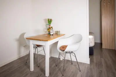 a white table and two white chairs in a room at Casita del Pueblo in Zandvoort