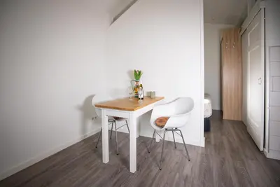 a white table and two white chairs in a room at Casita del Pueblo in Zandvoort