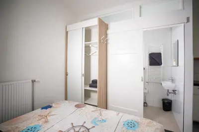 a bedroom with a bed and a bathroom with a sink at Casita del Pueblo in Zandvoort