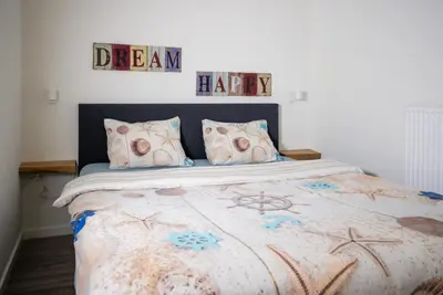 a bedroom with a bed and two signs on the wall at Casita del Pueblo in Zandvoort