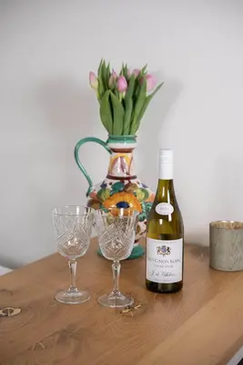 a bottle of wine and two glasses on a table at Casita del Pueblo in Zandvoort
