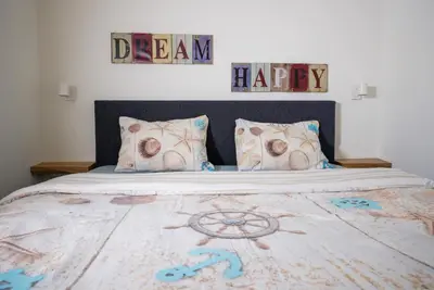 a bedroom with a bed with a sign that reads dream happy at Casita del Pueblo in Zandvoort