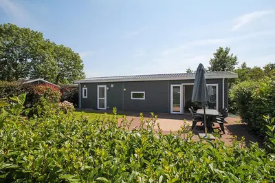 a black house with an umbrella in a yard at Holiday rentals in Velsen-Zuid