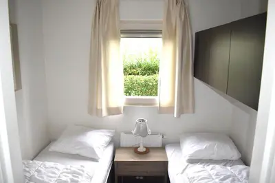 two beds in a room with a window at Holiday rentals in Velsen-Zuid
