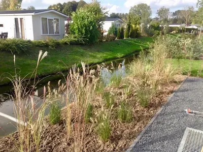 a garden with a pond in front of a house at Holiday rentals in Velsen-Zuid