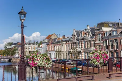 a city with buildings and a river with flowers on a fence at Appartement Kwaak in Zandvoort