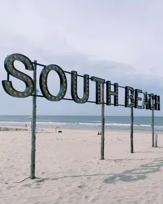 a sign that reads south beach on the beach at Appartement Kwaak in Zandvoort