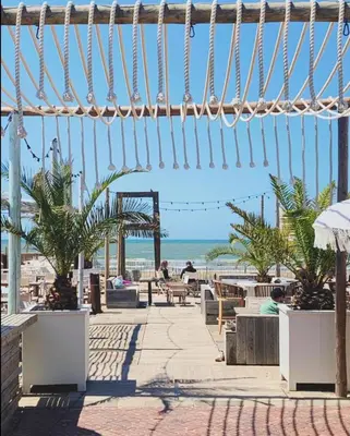 a patio with a view of the beach at Appartement Kwaak in Zandvoort
