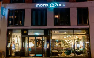 a store front of a building with tables and chairs at Motel One Amsterdam-Waterlooplein in Amsterdam