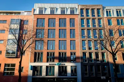 a large brick building with a unea clinic sign in front at Motel One Amsterdam-Waterlooplein in Amsterdam