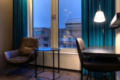 a room with a table and chairs and a window at Motel One Amsterdam-Waterlooplein in Amsterdam