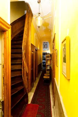 a hallway with a staircase in a house with yellow walls at Classy Room 17th C Canalhouse in Amsterdam