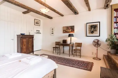 a room with a bed and a desk with a fan at Classy Room 17th C Canalhouse in Amsterdam