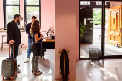 a group of people standing in an office with luggage at Conscious Hotel Westerpark in Amsterdam