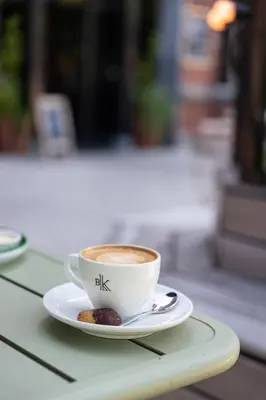 a cup of coffee on a plate on a table at Conscious Hotel Westerpark in Amsterdam