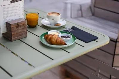 a table with a plate of croissants and a cup of coffee at Conscious Hotel Westerpark in Amsterdam