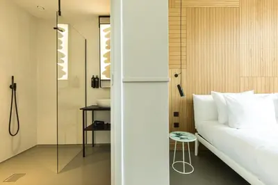 a bedroom with a bed and a glass shower at Conscious Hotel Westerpark in Amsterdam