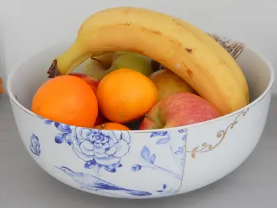 a bowl of fruit with a banana and oranges at Boutique B&B Nassau in Amsterdam