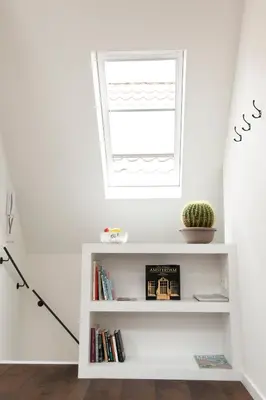 a white book shelf in a room with a window at Boutique B&B Nassau in Amsterdam