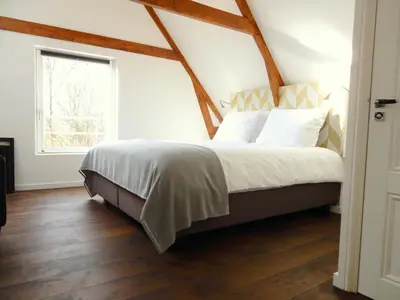 a bedroom with a bed with white sheets and a window at Boutique B&B Nassau in Amsterdam