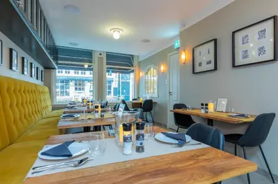 a dining room with wooden tables and chairs at ExLibris Boutique Hotel in Leiden