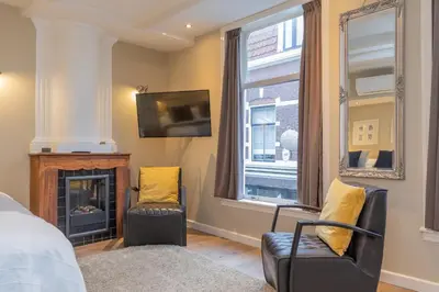 a bedroom with a bed and a tv and a fireplace at ExLibris Boutique Hotel in Leiden