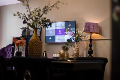 a living room with a table with vases and a tv at Hotel Sebastians in Amsterdam