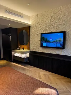 a room with a flat screen tv on a stone wall at Hotel Sebastians in Amsterdam