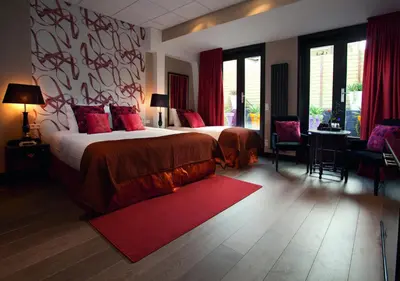 a bedroom with a large bed and a red rug at Hotel Sebastians in Amsterdam