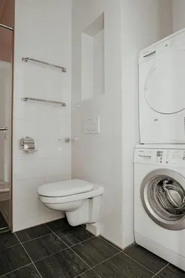 a bathroom with a toilet and a washing machine at Apartment De Zeeparel by Interhome in Egmond aan Zee