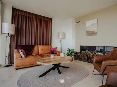 a living room with a couch and a coffee table at Apartment De Zeeparel by Interhome in Egmond aan Zee